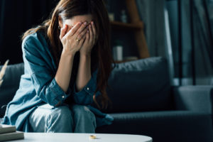 Photo of woman sitting with her head in her hands. Managing unrelieved trauma symptoms can be difficult. Meeting with an online therapist in Winter Park, FL can help you relieve your trauma symptoms.