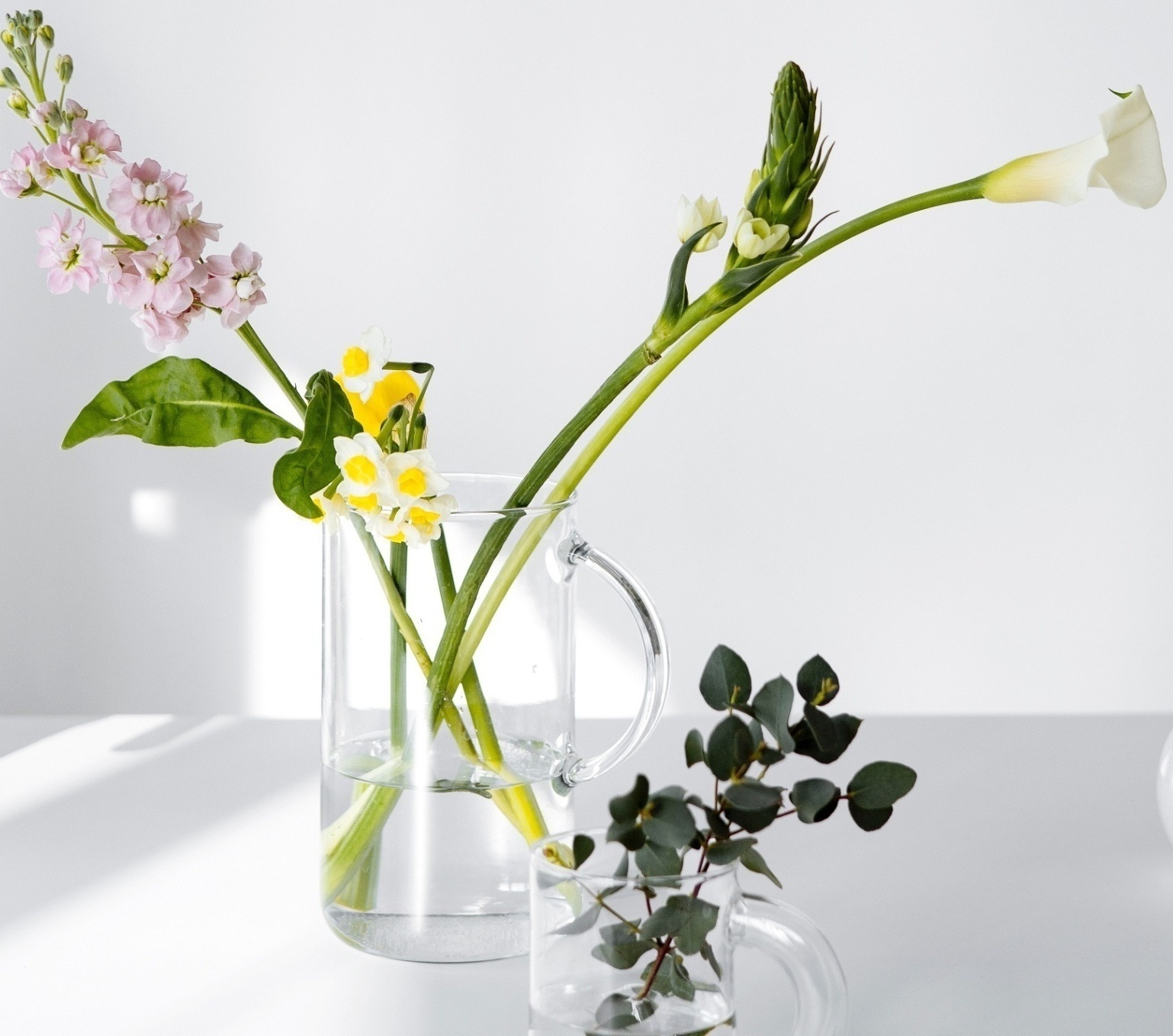 Image of a glass pitcher and cup with flowers in them in front of a white background. We are her for you with life transitions therapy in Orlando, FL 33701. You dont have to go through change alone with the support of a life transitions therapist in Orlando, Florida. Whether its moving, a job or something else you will get support in life transition counseling in Winter Park, FL 33601. Call today! 