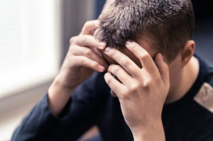 Photo of a young man holding his head representing someone with PTSD looking for trauma therapy in the Orlando, FL area. Our trauma therapists help people in Florida overcome PTSD using a variety of trauma therapy methods.