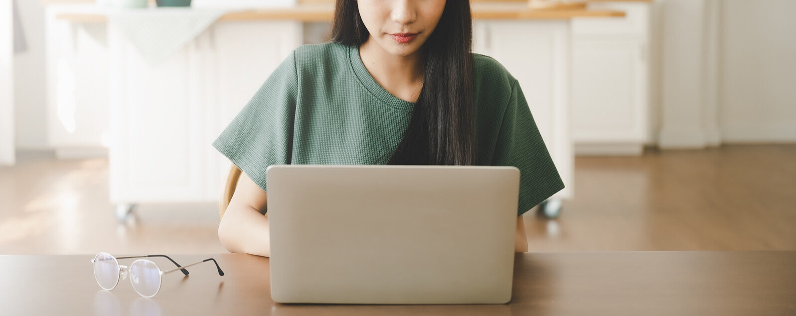 Image of a woman in a green shirt searching on her laptop for an EMDR therapist in Orlando, FL. Whether you are in Winter Park or Orlando EMDR can help as a form of trauma therapy.